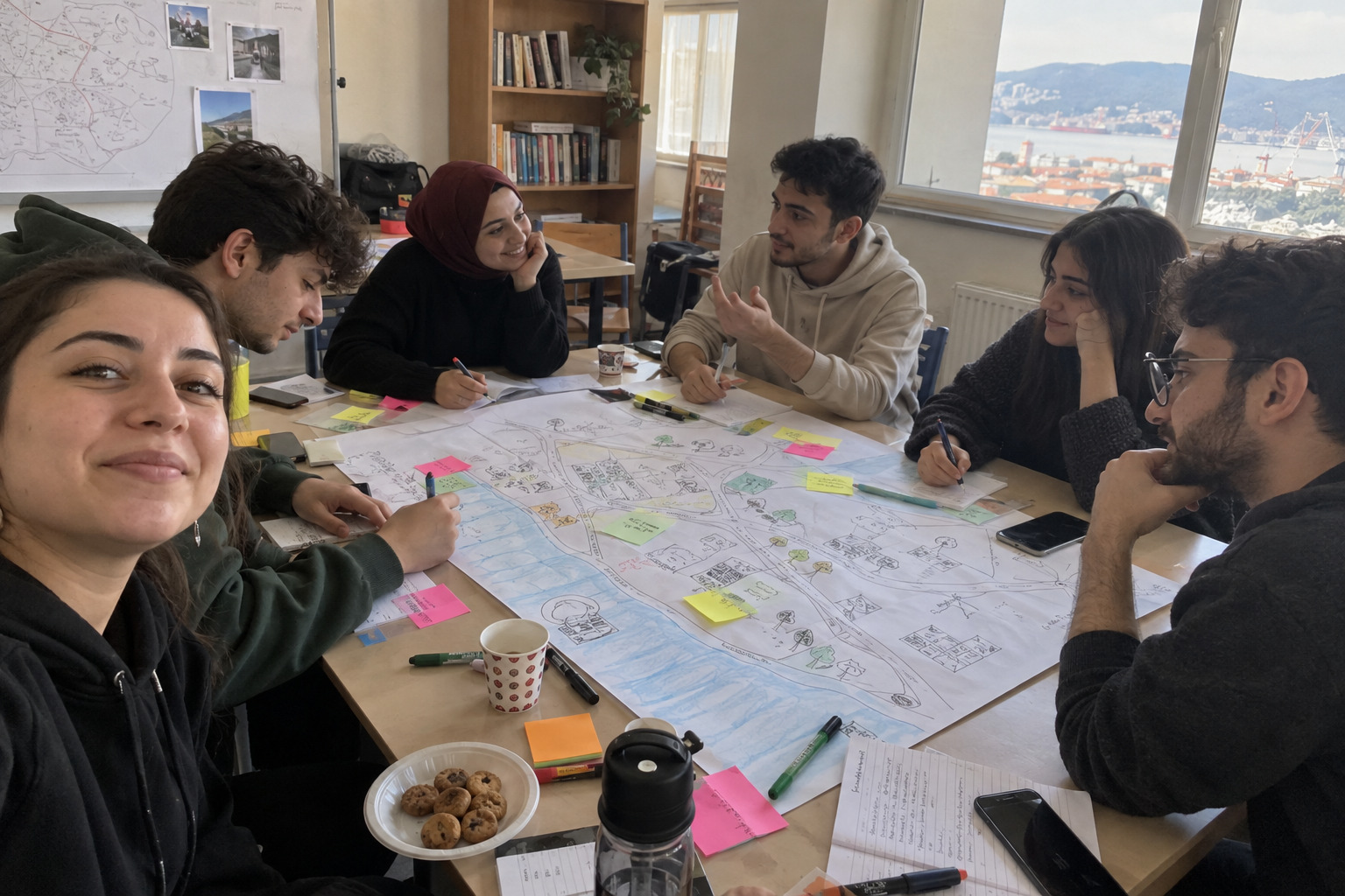 Young people working together on a large map with notes